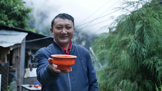  扎西巴珠展示他制作的木碗。新華網(wǎng) 旦增努布攝